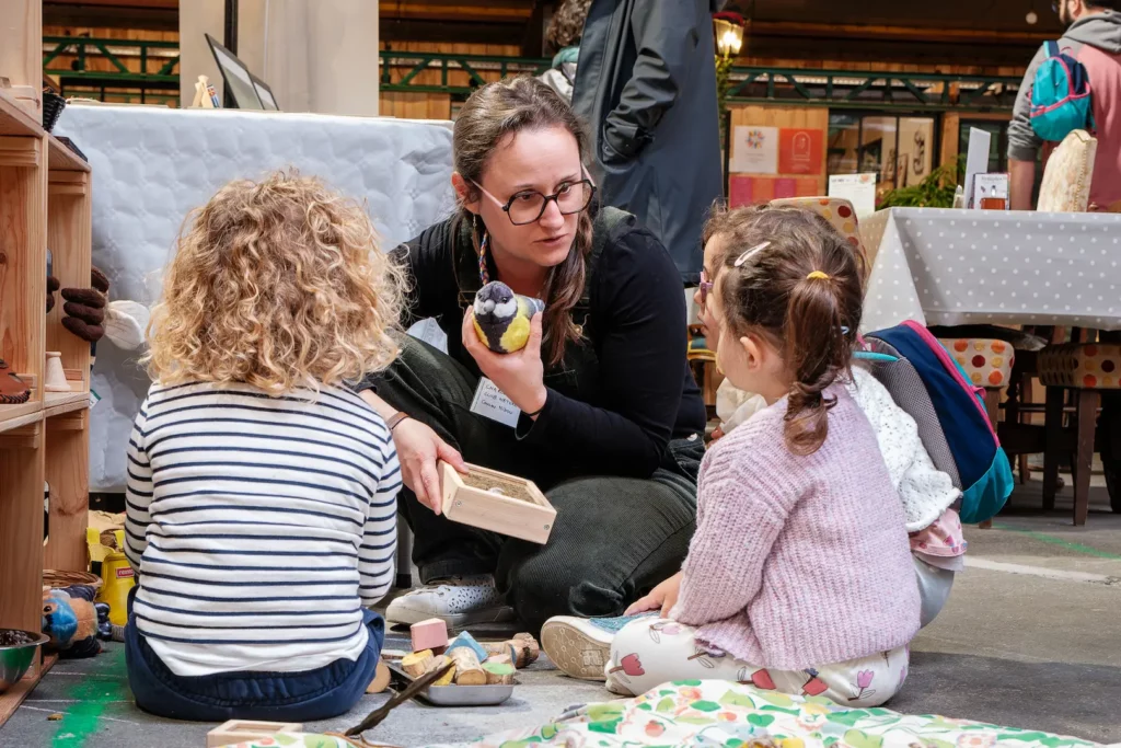 Animatrice présentant un atelier pédagogique à des enfants lors d’un événement associatif