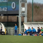 Staff et joueuses remplaçantes sur le banc lors d’un match de football à Montauban