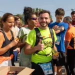 Coureur souriant lors du ravitaillement de la Course du Muguet 2025