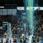 Joueurs de rugby entrant sur le terrain dans une ambiance de stade