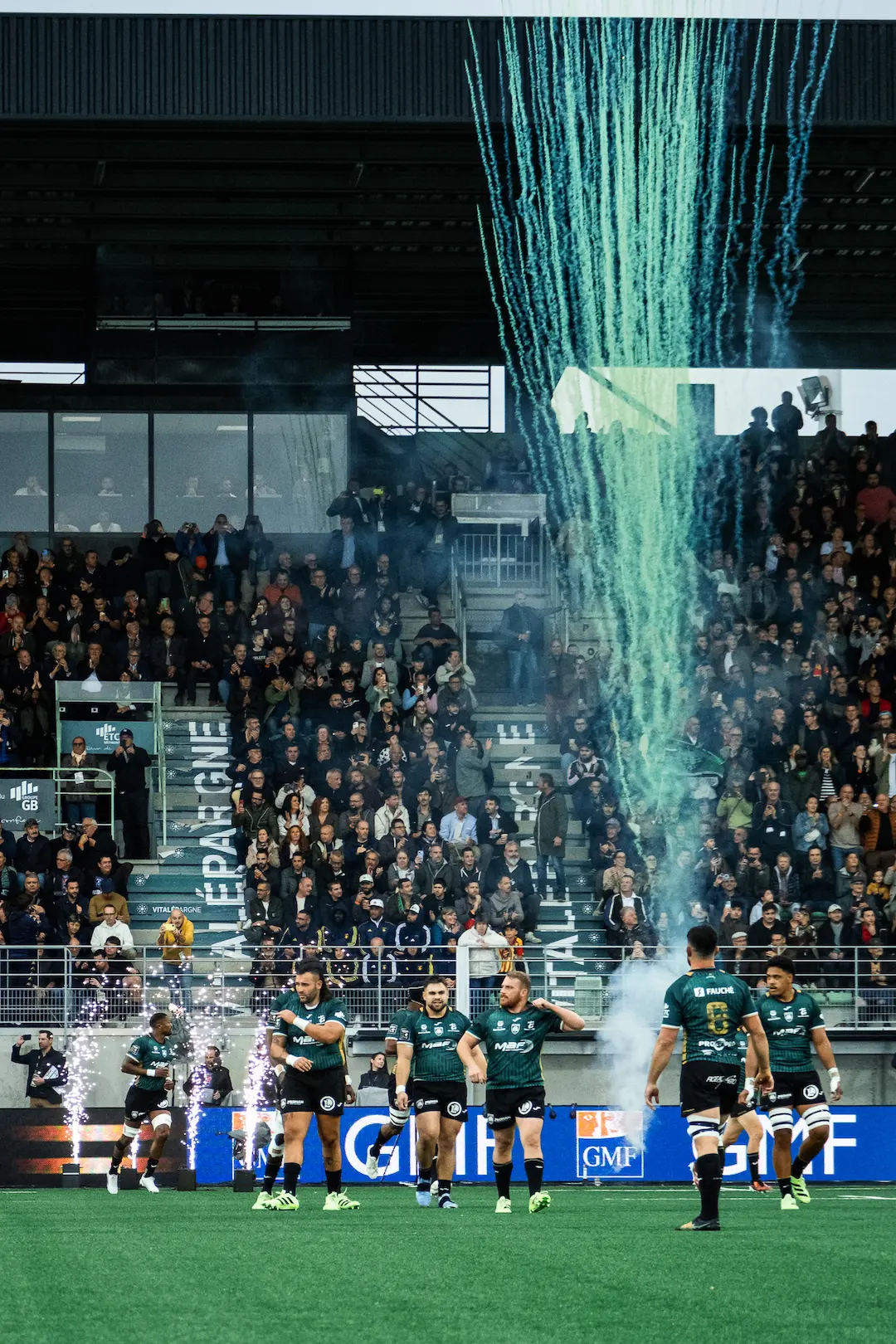 Joueurs de rugby entrant sur le terrain dans une ambiance de stade