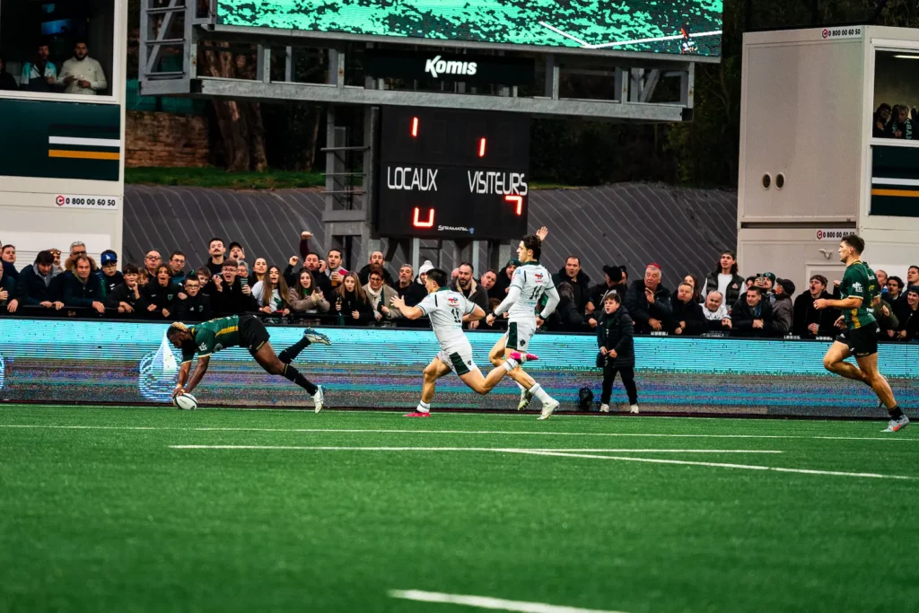 Joueur marquant un essai sous les encouragements du public