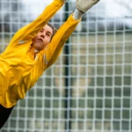 Gardienne de football féminin réalisant un arrêt en match