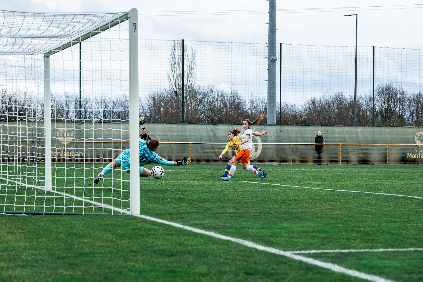 Face-à-face entre une attaquante et une gardienne en football féminin