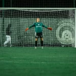 Gardien de football positionné devant son but pendant un match