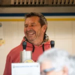 Alt Bénévole souriant dans la buvette lors d’un match de football à Montauban