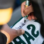 Joueur de rugby signant un maillot de l’US Montauban après le match