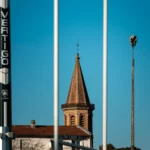 Clocher de Montauban visible entre les poteaux du stade de rugby de Sapiac