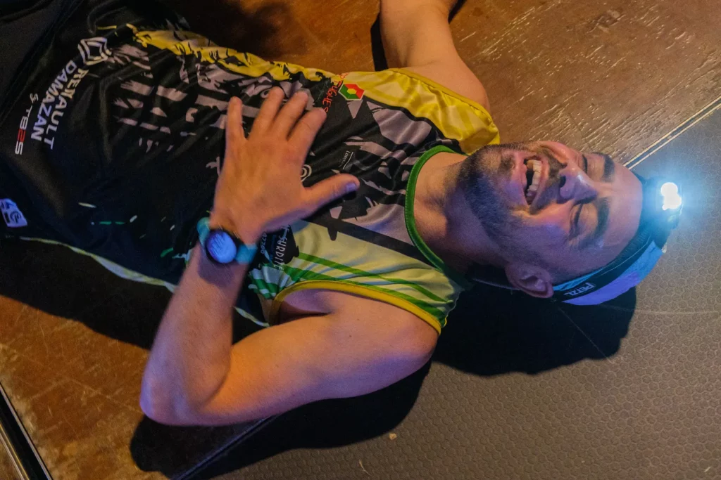 Athlète allongé au sol après un effort intense lors d’un trail indoor