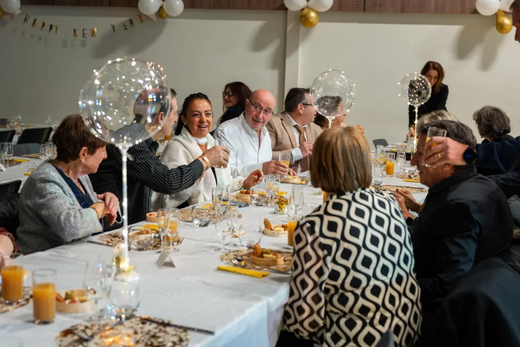 Invités réunis autour d’une table lors d’un réveillon privé à Montauban, échangeant et trinquant dans une ambiance conviviale