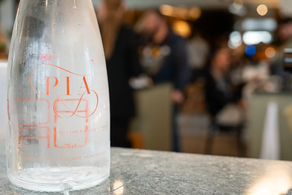 Détail d’une bouteille sur une table dans un restaurant à Montauban avec une ambiance en arrière-plan