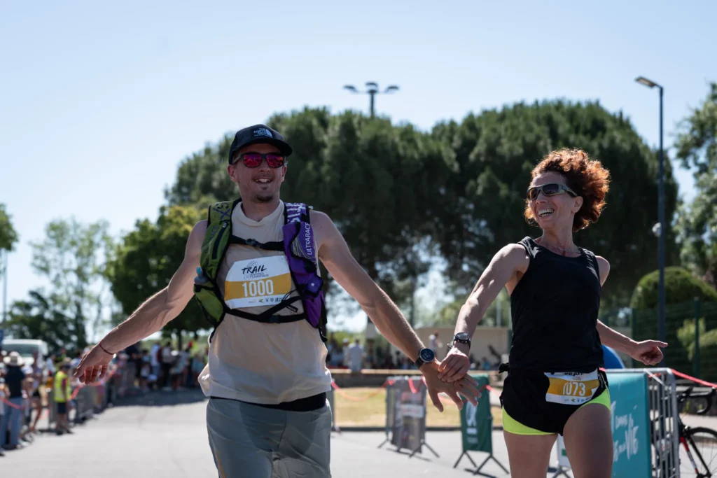 Deux participants franchissant ensemble l’arrivée du Trail Rivières et Châteaux