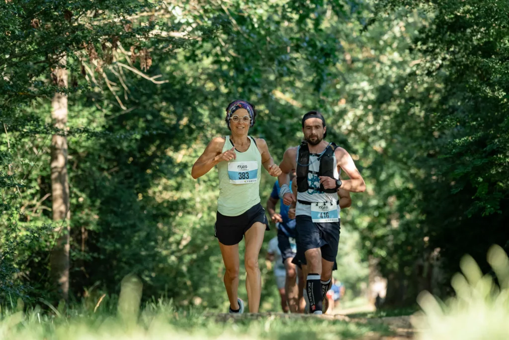 Deux participants courant sur un chemin forestier pendant le Trail Rivières et Châteaux
