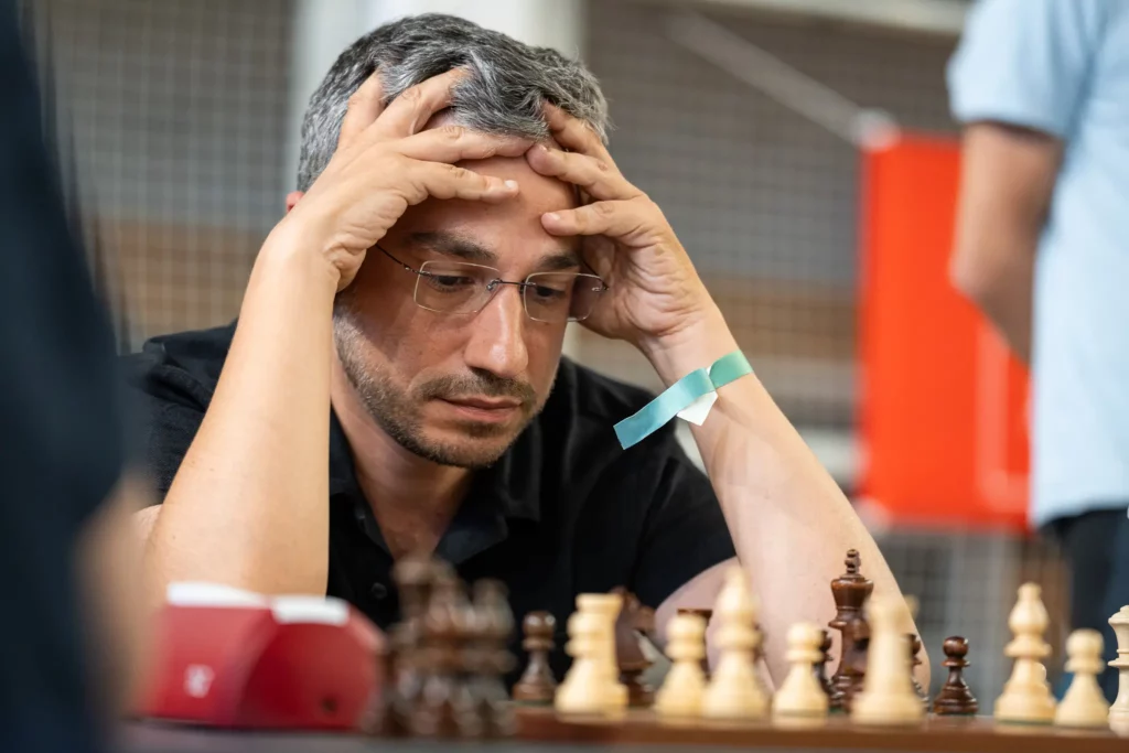 Un joueur tient sa tête entre ses mains pendant une partie d’échecs à Montauban
