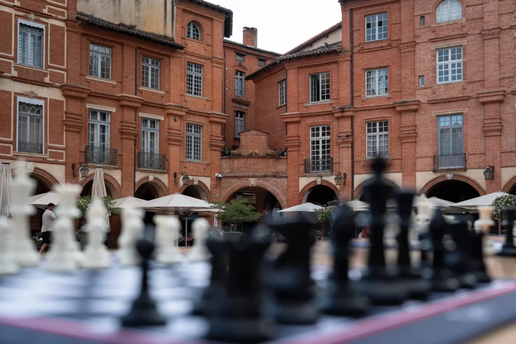 Échiquier installé devant les façades en briques de la place Nationale à Montauban